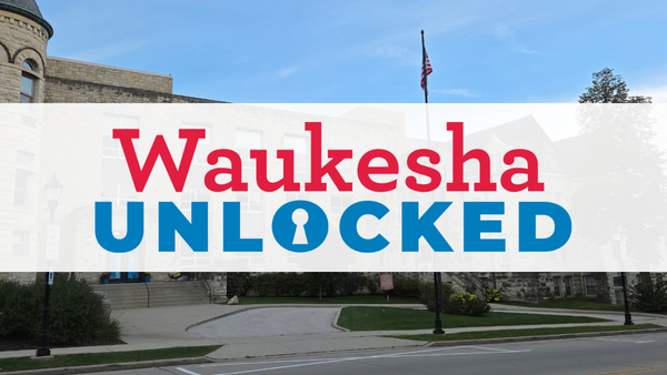 waukesha unlocked logo on a white stripe overlayed over the museum - a cream colored stone building.